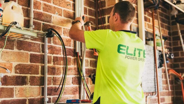 Electrician performing solar battery installation for sustainable energy storage in a home setting.